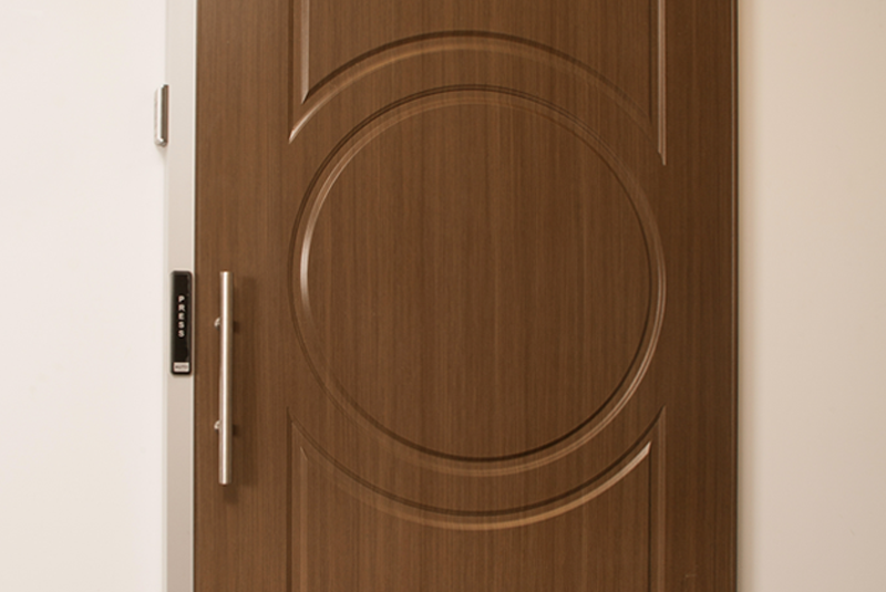 Sliding wooden door with a modern design and circular pattern, installed in an office setting