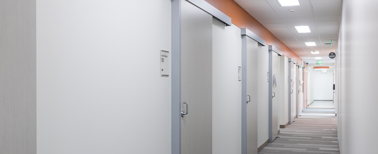 A hallway lined with commercial sliding doors in a medical facility. 