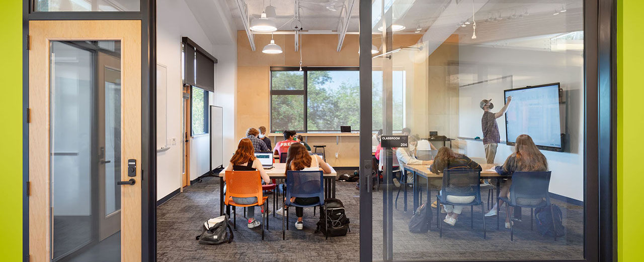 Classroom with a large glass sliding door, students engaged in learning inside