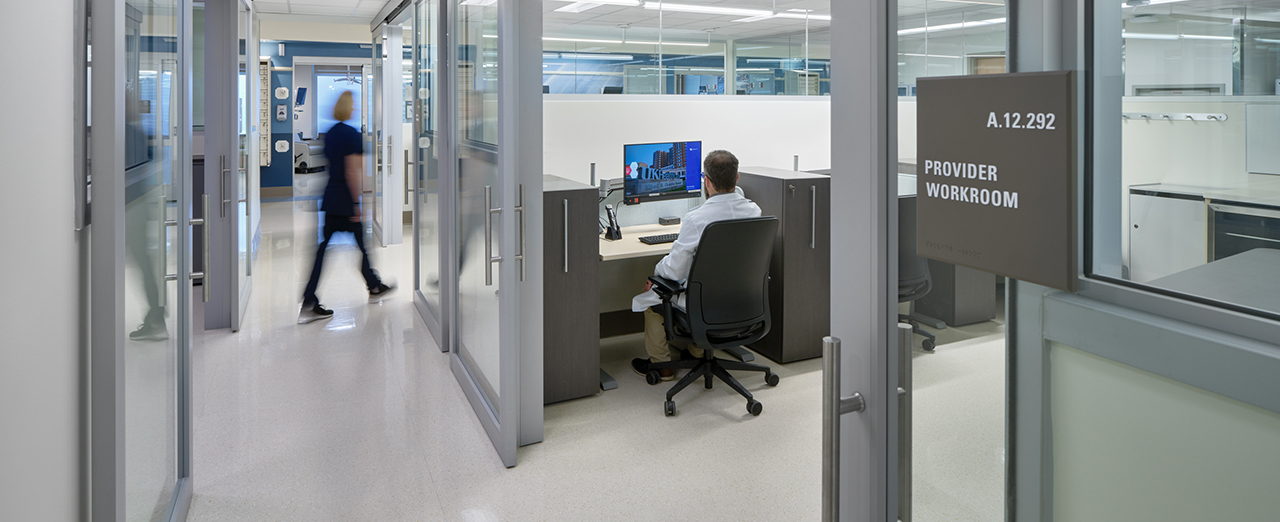Interior view of a healthcare facility with commercial sliding doors leading to a workroom