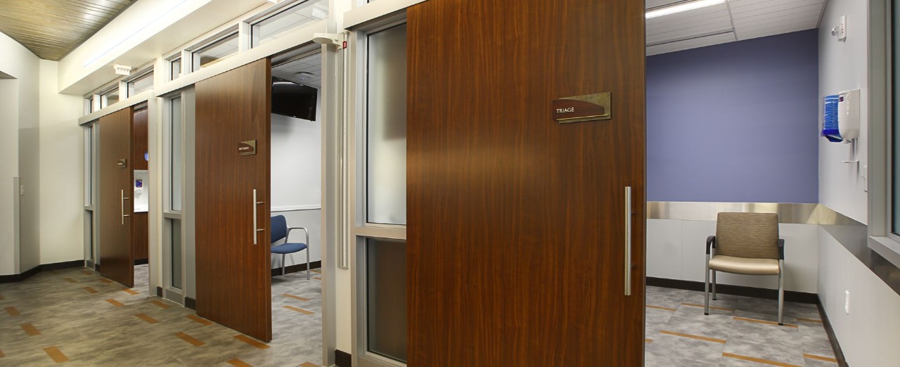 3 exam rooms with open commercial sliding barn doors.